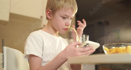 A little boy enjoys his breakfast at the kitchen table in a natural, authentic moment. Candid emotions, messy hair, and genuine childhood joy make this scene heartwarming