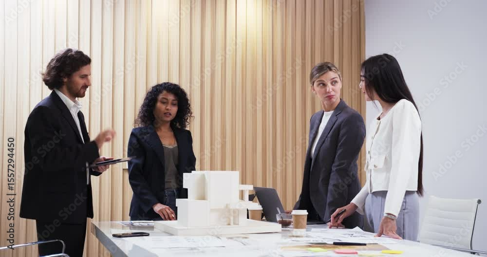 Team of architects collaborates on assembling a modern building model. Professionals work together around the table, adjusting structure elements and reviewing design plans in a creative office. Team of architects collaborates on assembling a modern building model. Professionals work together around the table, adjusting structure elements and reviewing design plans in a creative office.