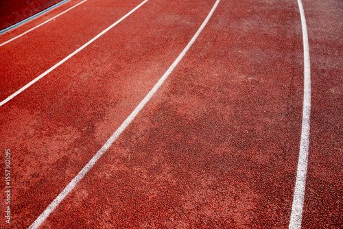 close up view of red running track with white lane markings in outdoor stadium athletics background texture sports competition race surface fitness training jogging path summer sports event field