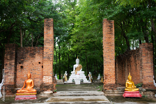 Fotografie Ancient antique white buddha statue in antique ruin ubosot for thai people trave