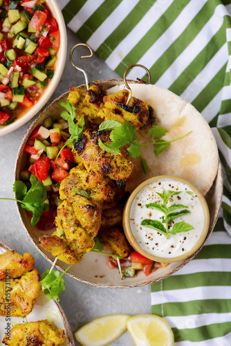 Persian chicken kebab with yogurt sauce, pitas and shiraz vegetable salad.selective focus