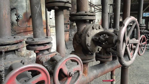 Close-up of rusty shut-off valves and pipelines showing signs of long-term use and natural aging.