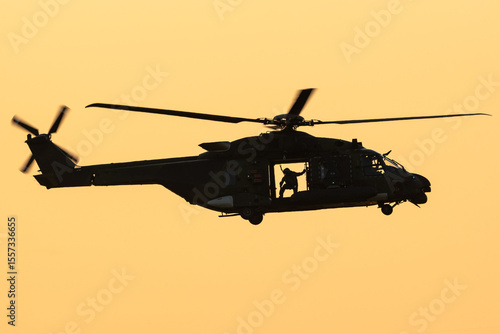 A helicopter is flying during a beautiful sunset. 