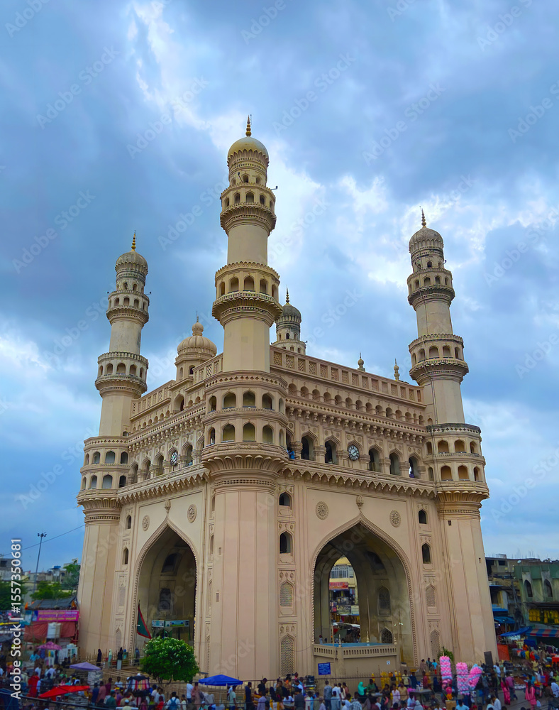 Fototapeta premium Charminar Monument in Hyderabad Under Dramatic Cloudy Sky with City Crowd