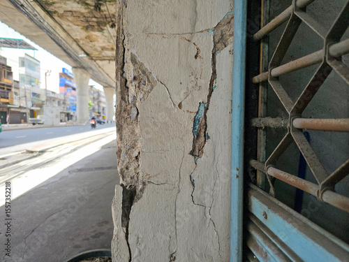 The pillars and exterior of the building are damaged and show visible cracks.