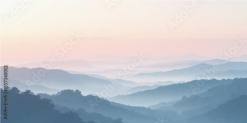 Misty mountain landscape in the early morning light with fog covering the hills and trees