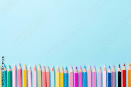 Colorful pencils are arranged in a row at the bottom, creating a vibrant border against a light blue backdrop