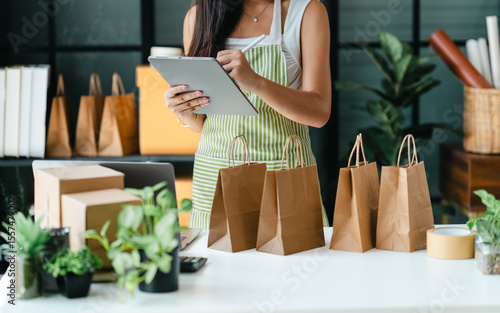 Business owner entrepreneur packing cardboard box preparing parcel for shipment, Online marketing