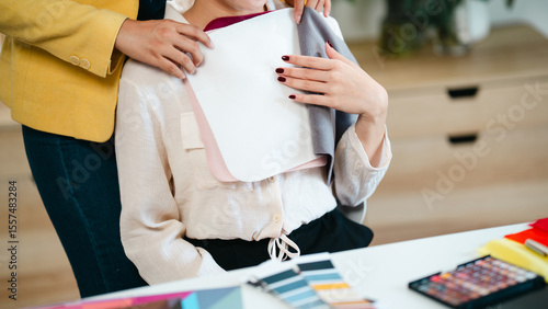 Photography Two female experts analyzing personal color palette and guiding client at profes