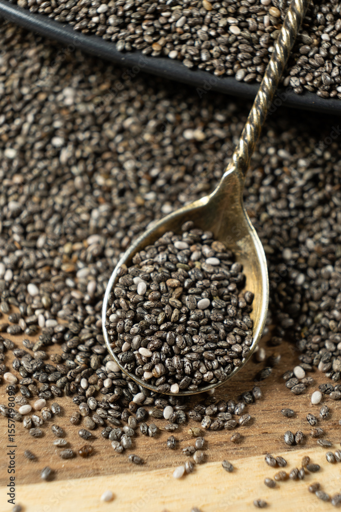 Chia seeds in a spoon on a wooden background, close-up. Chia seeds in a spoon on a wooden background, close-up.
