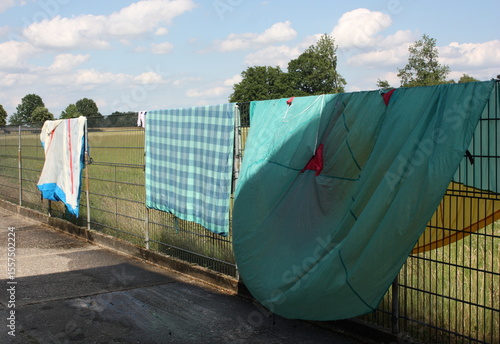 Campingutensilien nach dem Zelten zum Trocknen über einen Doppelstabzaun gehängt, in Lippetal Büninghausen an der Buschstraße.
