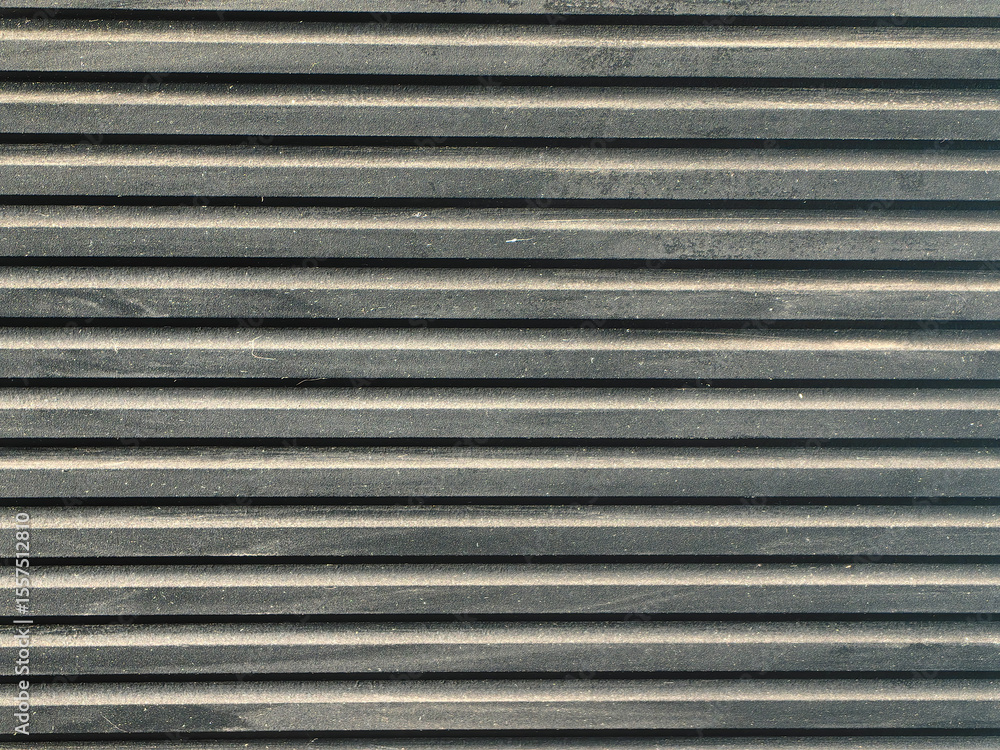 Detailed view of a dark, textured surface with parallel ridges and a hint of dust, ideal for backgrounds. Detailed view of a dark, textured surface with parallel ridges and a hint of dust, ideal for backgrounds.