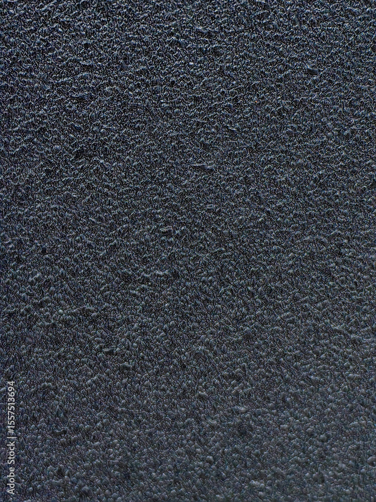 Fototapeta premium A detailed close-up of a dark, textured and grainy surface, with a subtle pattern