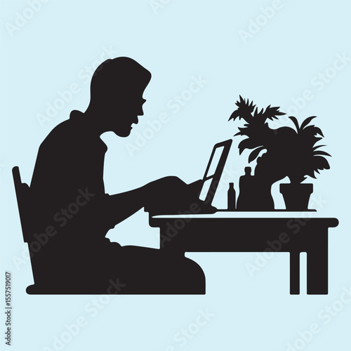 Silhouette of a Person Working on Laptop at Desk