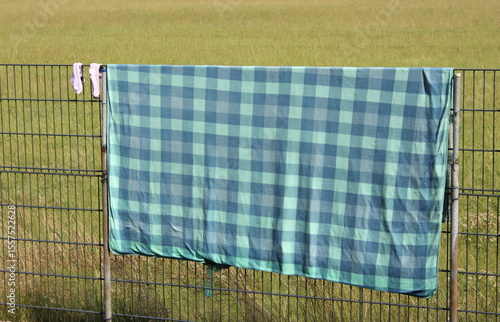 Campingutensilien nach dem Zelten zum Trocknen über einen Doppelstabzaun gehängt, in Lippetal Büninghausen an der Buschstraße.