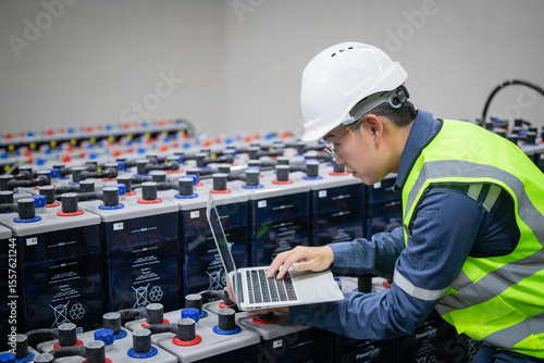 Konstfotografi Technician inspects backup battery power system using laptop in industrial setti