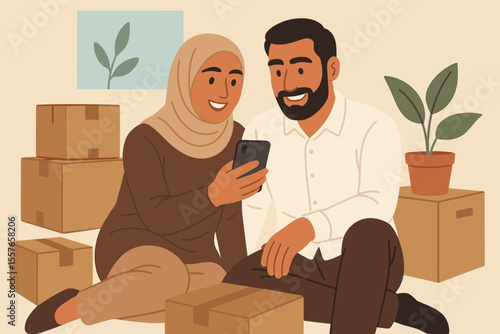 Happy Muslim couple moving into a new home. Woman in hijab and man sitting on the floor among cardboard boxes, using a smartphone. Relocation, real estate, new beginning concept.