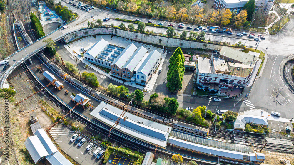 Naklejka premium Drone aerial photograph of a train arriving and departing at the Katoomba Train Station near the Great Western Highway in the Blue Mountains, NSW, Australia.