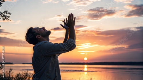 Man praying to God on sunset. Man prays to the open sky. Chrisitan prayer. A man raises his hands to the sky in prayer. Chrisitanity concept. 
