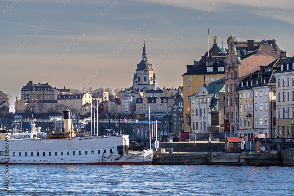 Obraz premium Historic Gamla Stan waterfront in Stockholm with ferries and church spire