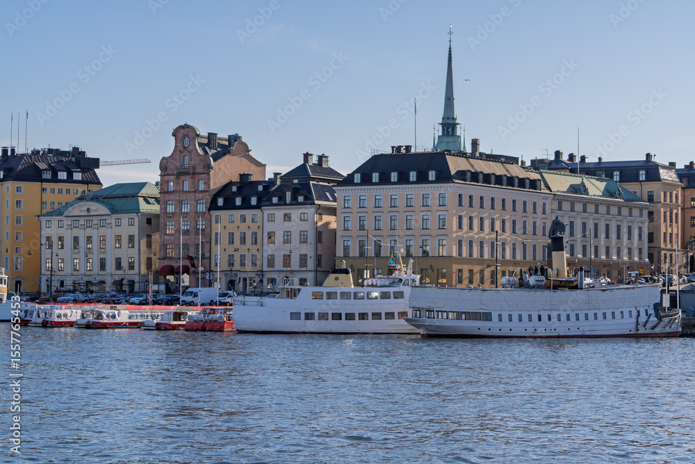 Fototapeta premium Historic Gamla Stan waterfront in Stockholm with ferries and church spire