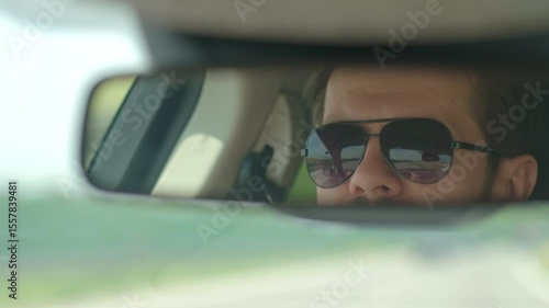 Wallpaper Mural Close-up of man face in sunglasses reflected in car rearview mirror. Male driver driving car. Travel and road trip concept Torontodigital.ca