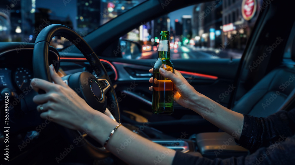 Obraz premium Interior of a car at night. Female driver with one hand on the wheel and the other holding a beer bottle. Blurred city lights outside.