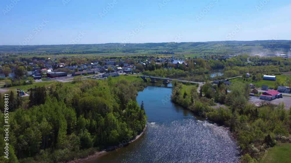 Panoramic aerial view of the picturesque village of Price and its road bridge spanning the Mitis River, a renowned salmon river with a lush country setting. Quebec, Canada, 2025. Panoramic aerial view of the picturesque village of Price and its road bridge spanning the Mitis River, a renowned salmon river with a lush country setting. Quebec, Canada, 2025.