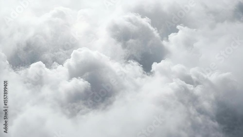 A cloudy sky with a few clouds in the background. The sky is mostly white. The clouds are scattered throughout the sky