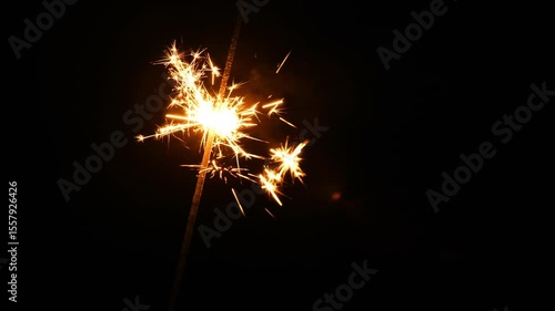 Sparkling fireworks with gold bokeh.Christmas wallpaper. Festive glitter background with fireworks splashes on black background. 4k footage