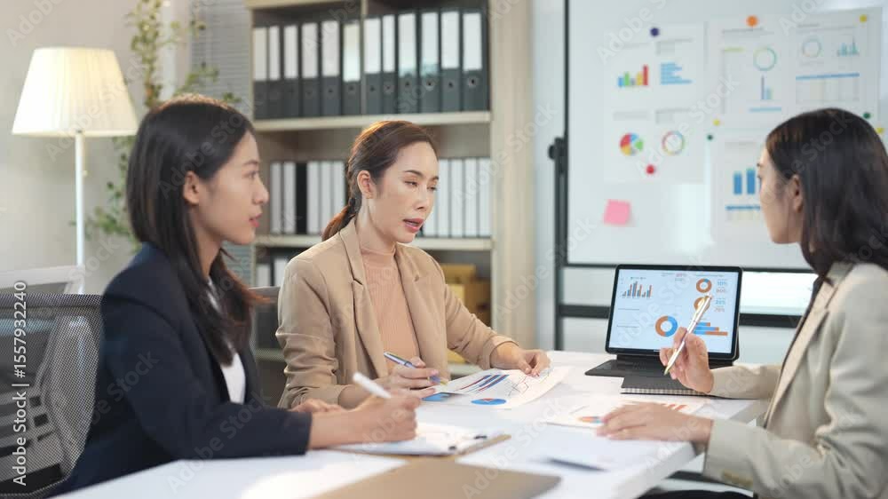 Businesswomen discussing financial report during meeting Businesswomen discussing financial report during meeting
