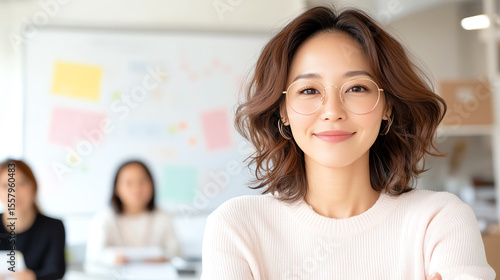 Free Download A confident young woman smiles at the camera while leading a professional team meeting in a bright, modern office space. - GFXLoad