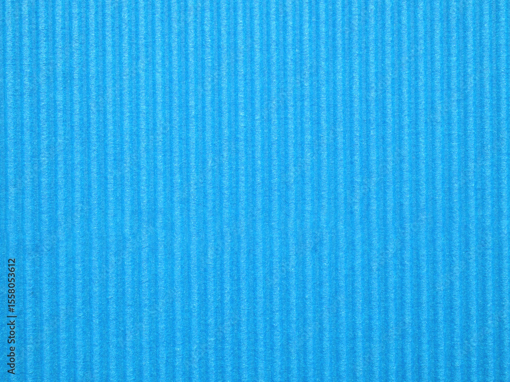 Obraz premium Top view, blank textured, vibrant blue corrugated cardboard surface. The distinct parallel ridges and grooves run vertically across the frame. Concept for design, image, text, and banner.