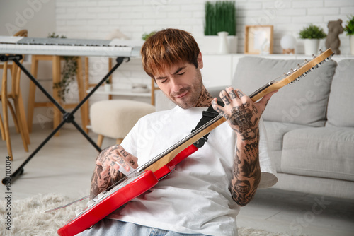 Cool tattooed young man pla...