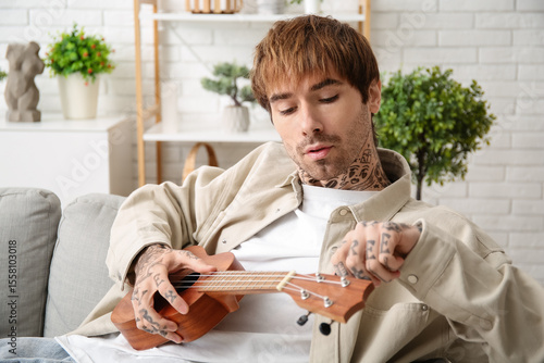 Cool tattooed young man pla...