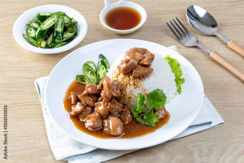 Chicken in brown sauce or gravy sauce with rice on a wooden table - Asian food style Chicken in brown sauce or gravy sauce with rice on a wooden table - Asian food style