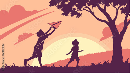 Silhouette of two children playing with a paper airplane under a tree at sunset on a grassy hill side