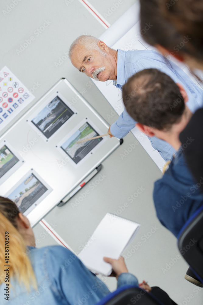 Fototapeta premium teacher preparing students for drivers licenses test in driving school