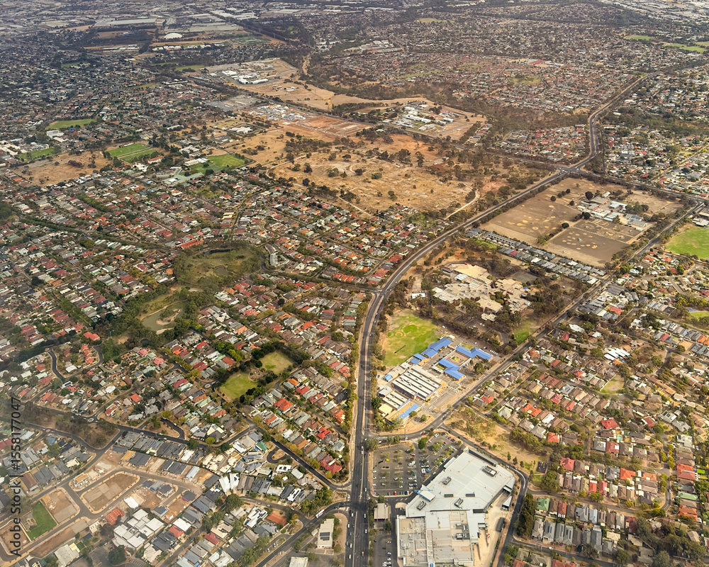 Obraz premium Aerial view of the suburbs houses and roads around the city of Adelaide in South Australia during a dry summer