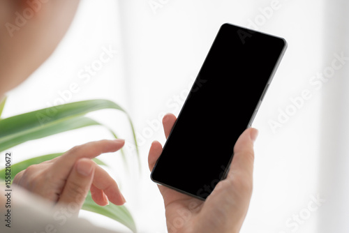 スマートフォンを手に持つ人物の手元