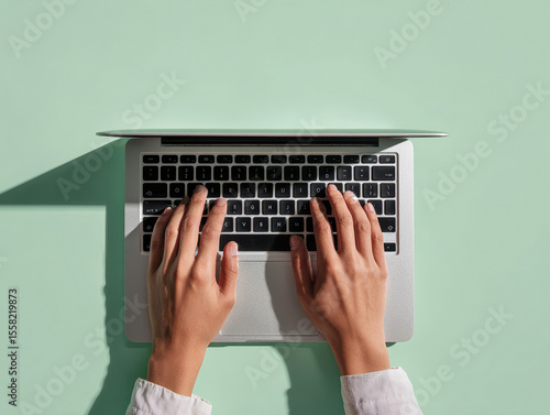 Close-up, hands typing on laptop keyboard, laptop mockup, green background, flat lay view, minimalist style, high-resolution photography, detailed, isolated, pastel color background, st - AI-Generated
