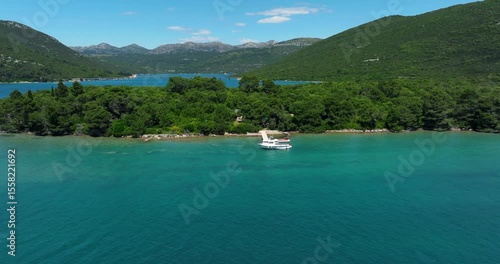Boat Docked At Oyster Farming Facility On Bay Of Mali Ston In Zaton Doli, Croatia. aerial pullback shot