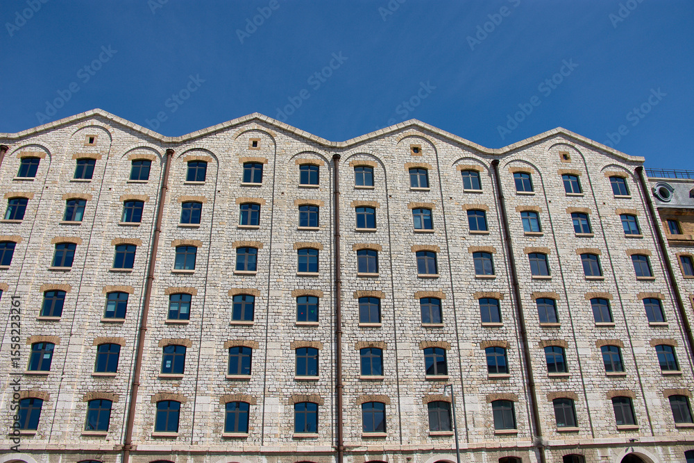 Fototapeta premium Stone facade of Les Docks in Marseille, France, a former port factory restored as a modern commercial and business center