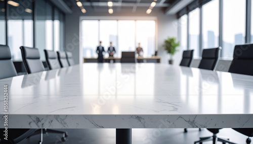 Close-up of a wide conference desk against a blurry modern bright office with worker background.
