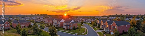 Breathtaking Aerial View of a Luxurious Gated Community at Sunset: A Charming Cul-de-Sac with Colonial Homes under a Colorful Sky