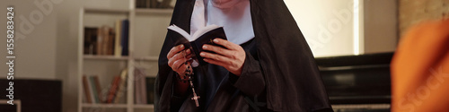 Caucasian nun standing in prison library reading book and holding rosary beads, bookshelves visible in background, engaging in religious or educational activity