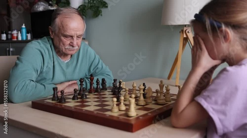 grand parent with granddaughter play chess together at home. Quality Time. Family having fun playing at home