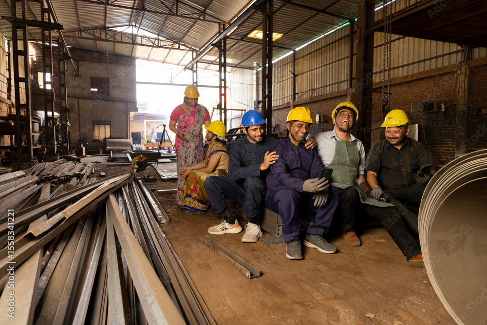 Fototapeta premium Team of indian engineers wearing safety hard hat and having a fun together at industrial factory taking break from work, skill india concept.