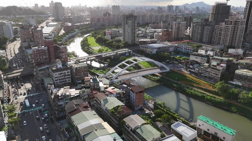 Aerial Taipei Cityscape with White Arched Bridge over Urban Riverfront.