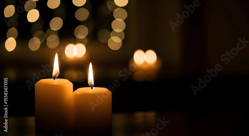Two burning candles on dark background